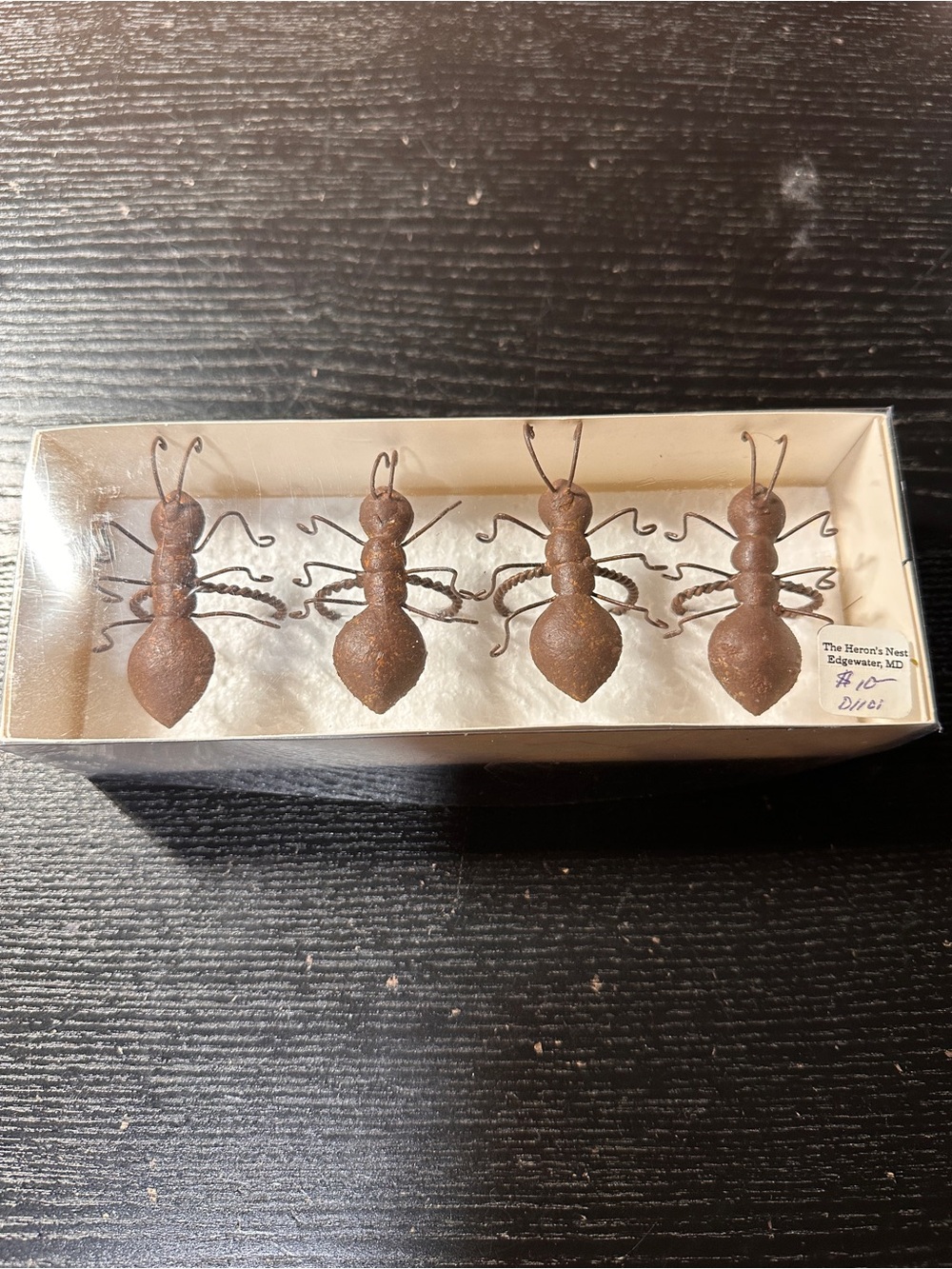 Handmade rustic metal ant napkin rings featuring textured bodies and wire legs.